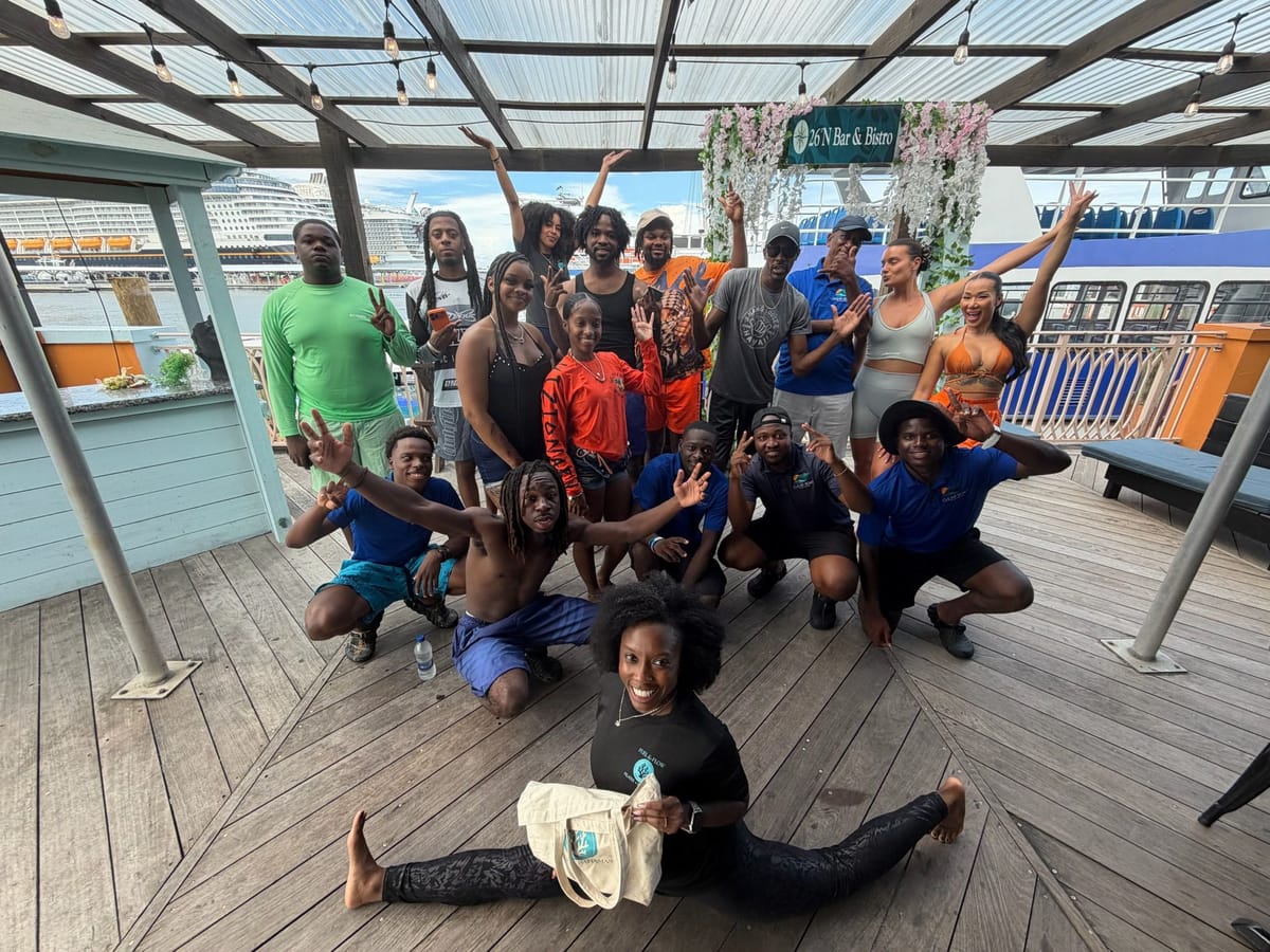 The Pilates Brunch group gathered on a wooden terrace, one guest in a split at the front holding a Fuel & Flow tote